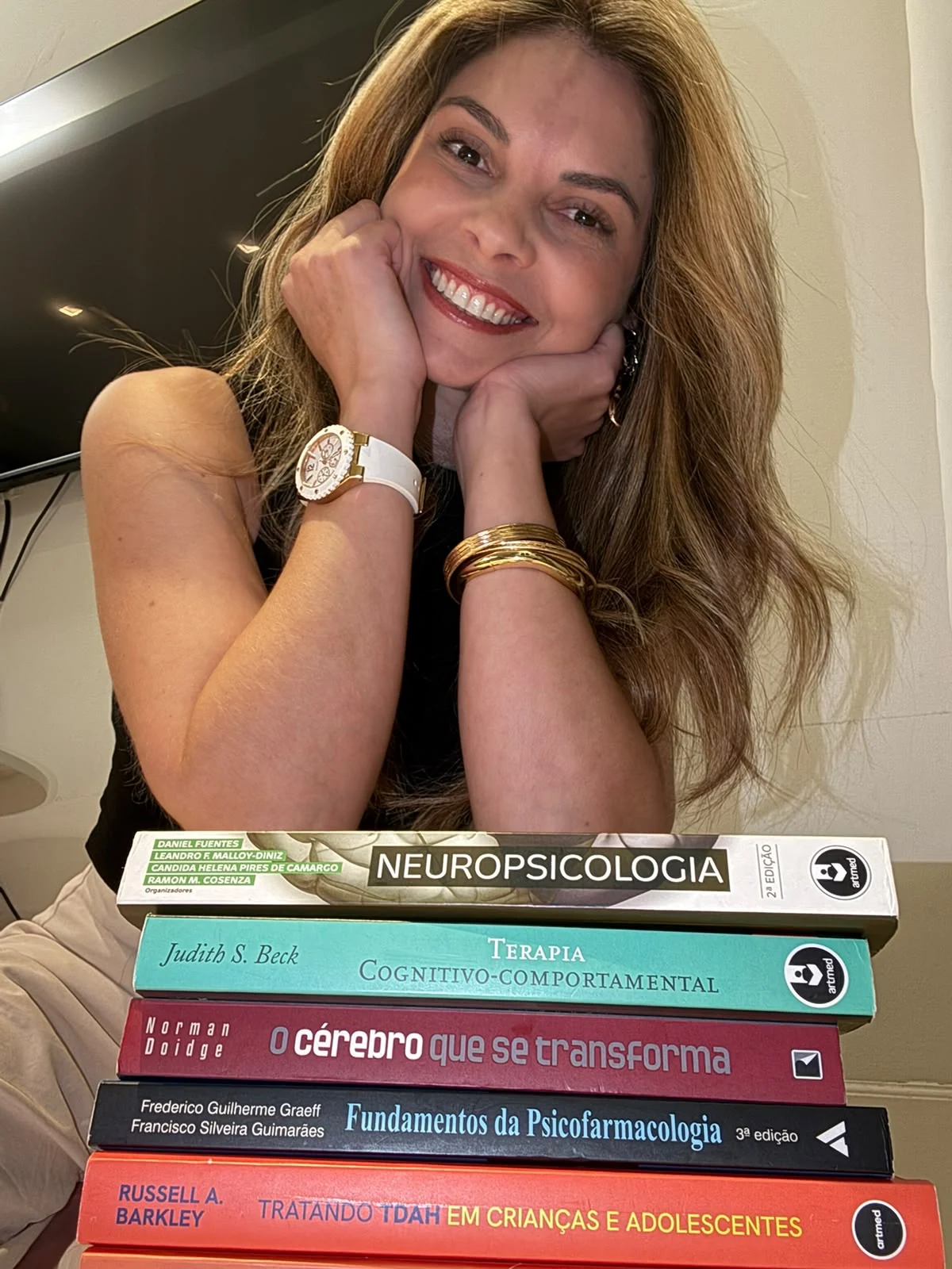 Juliana Costa em seu consultório, junto a livros de psicologia